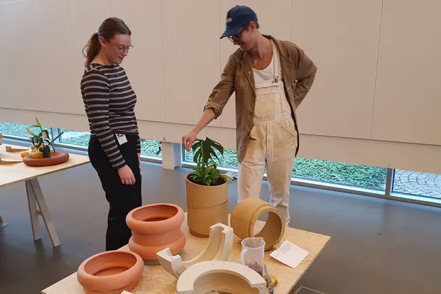 Two people looking at terracotta pots.