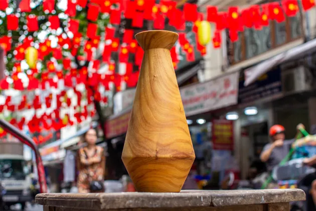 Photo of a wooden sculpture with red bunting behind it.